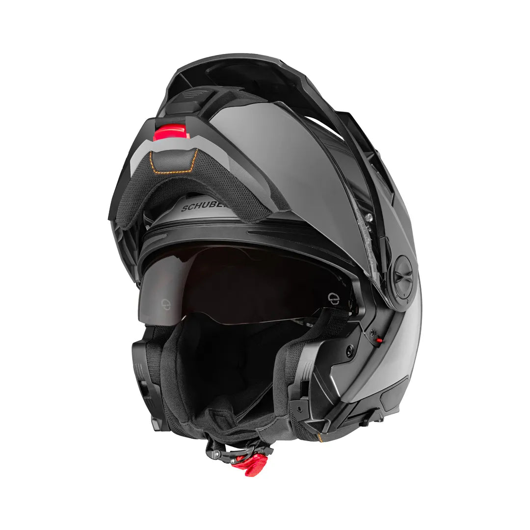 Schuberth E2 grå mc-hjälm med öppningsbar funktion och integrerat visir, visad i uppfällt läge. Perfekt för säker och bekväm motorcykelkörning.