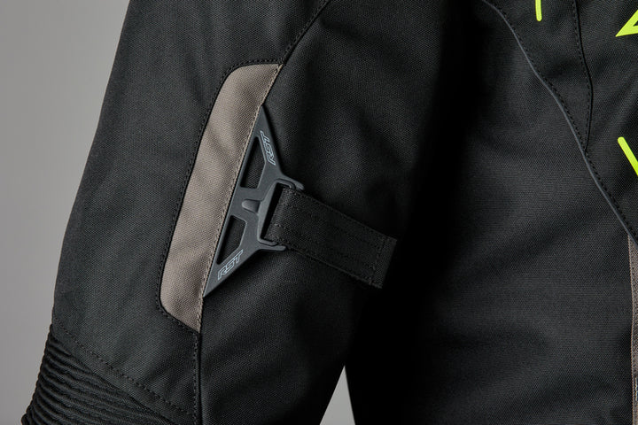 Närbild på ärmdetalj av RST Textil Mc-Jacka S-1 Svart/Flu med justerbart spänne för optimal passform och rörelsefrihet.